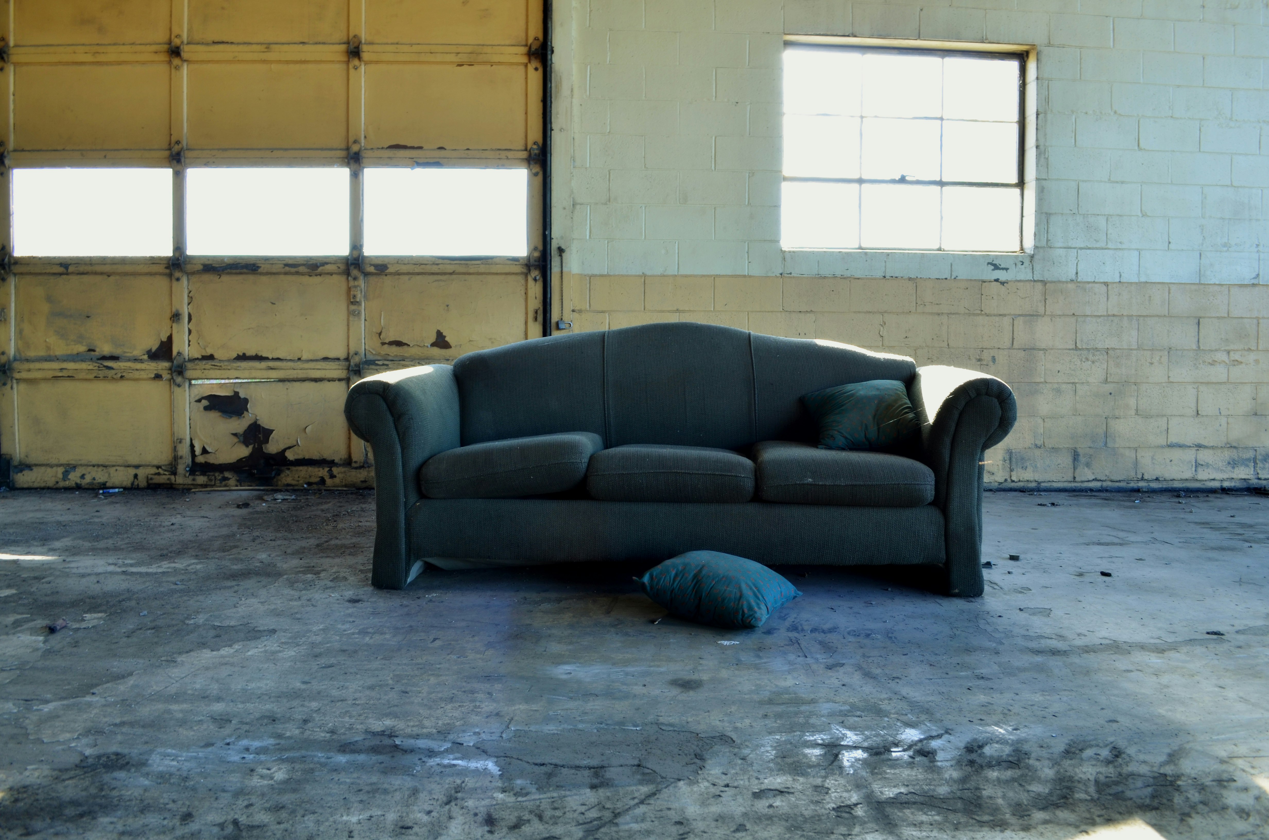 black fabric 3-seat sofa in front of wall and garage door